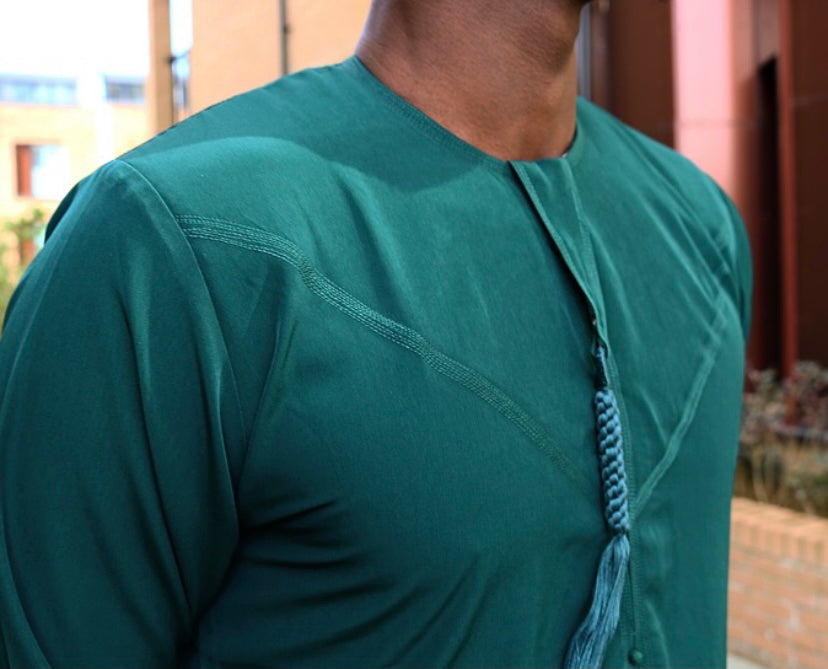 A man wearing a emerald green emirati thobe