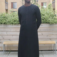 A man in a black emirati thobe