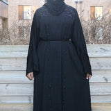 A woman wearing a black nailah abaya