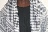 A man wearing an imaamad black and white scarf