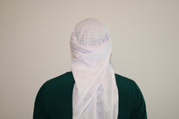 A man wearing an imaamad white scarf