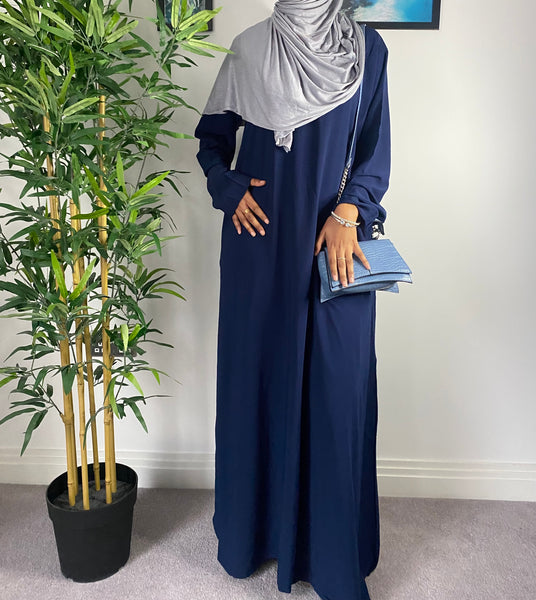 A woman wearing a simple navy blue abaya