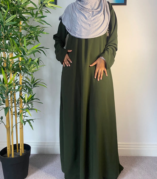 A woman wearing a simple forest green abaya