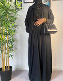 A woman wearing a simple black abaya