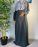 A woman wearing a simple grey abaya