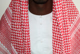A man wearing an imaamad red and white scarf
