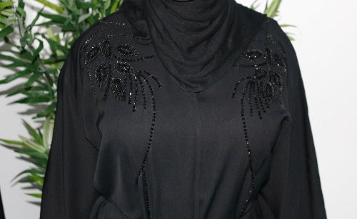 A woman wearing a black nailah abaya