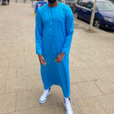 A man wearing a light blue emirati thobe 
