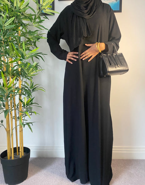 A woman wearing a simple black abaya