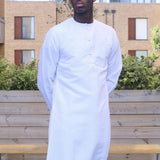 A man wearing a white emirati thobe